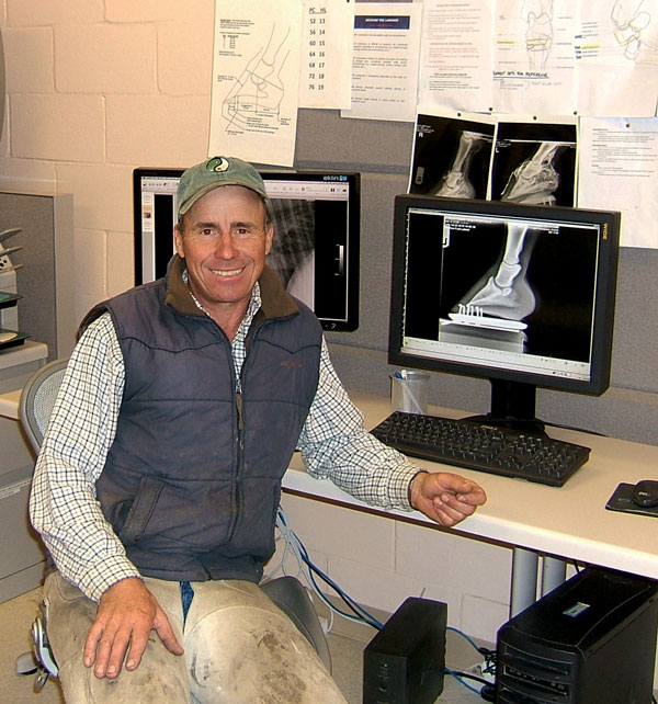 Pete Healey sitting at his desk with computer screens in the background